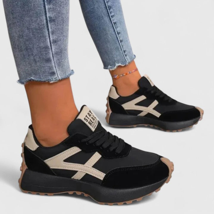 A woman wearing neutral contrast orthopaedic trainers on a city walk.