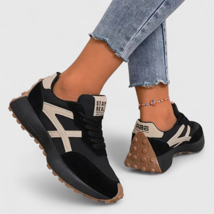 A woman wearing neutral contrast orthopaedic trainers on a city walk.