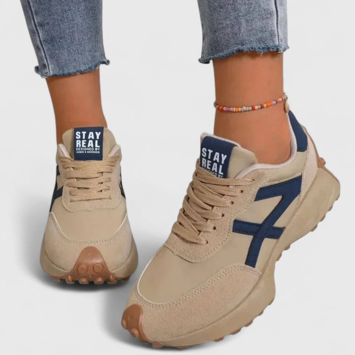 A woman wearing neutral contrast orthopaedic trainers on a city walk.