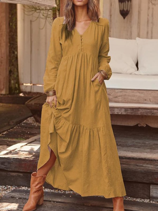 Woman walking through the countryside in the Georgia floral maxi dress with long sleeves and a flowing flounced hem.