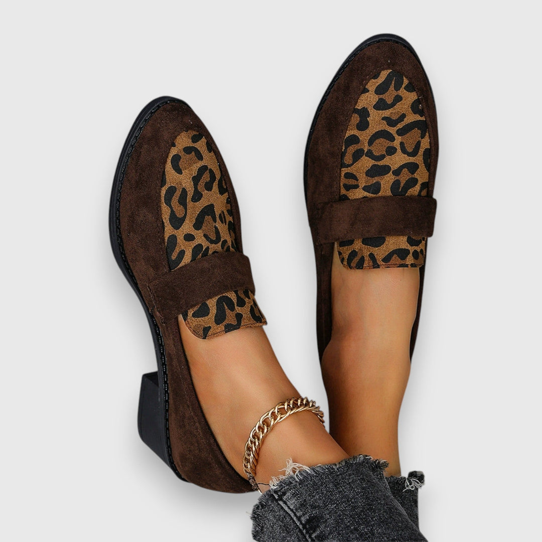 A woman wearing soft grey house slippers, relaxing comfortably at home.