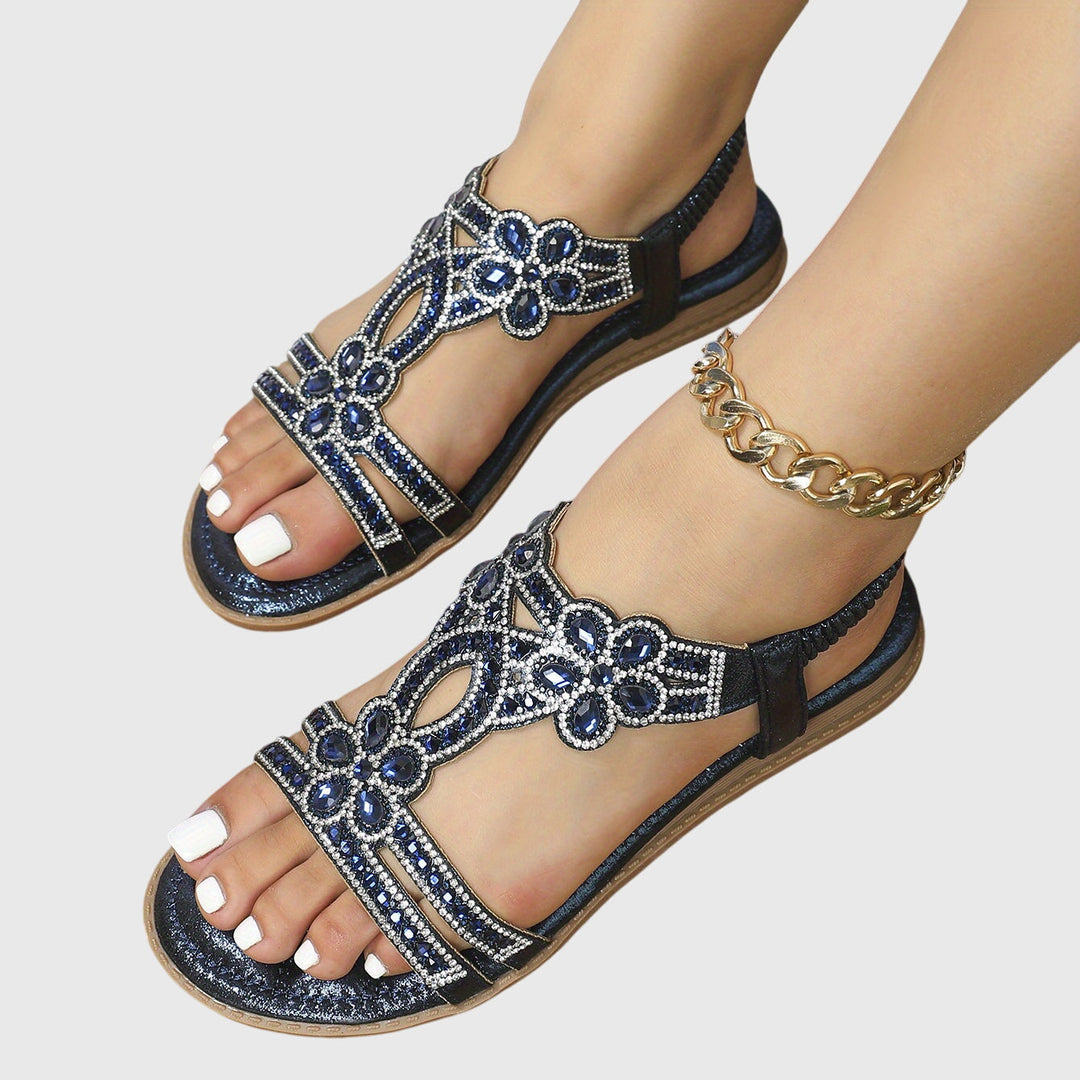 A woman wearing elegant gold open-front sandals with supportive straps and a cushioned sole.
