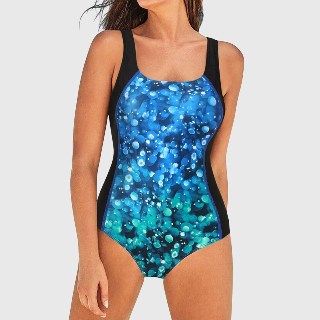 A woman wearing a figure-flattering swimsuit with a fresh summer print, relaxed by the pool.