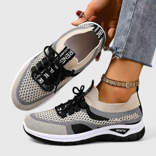 A woman lacing up light, breathable orthopaedic trainers before a walk.