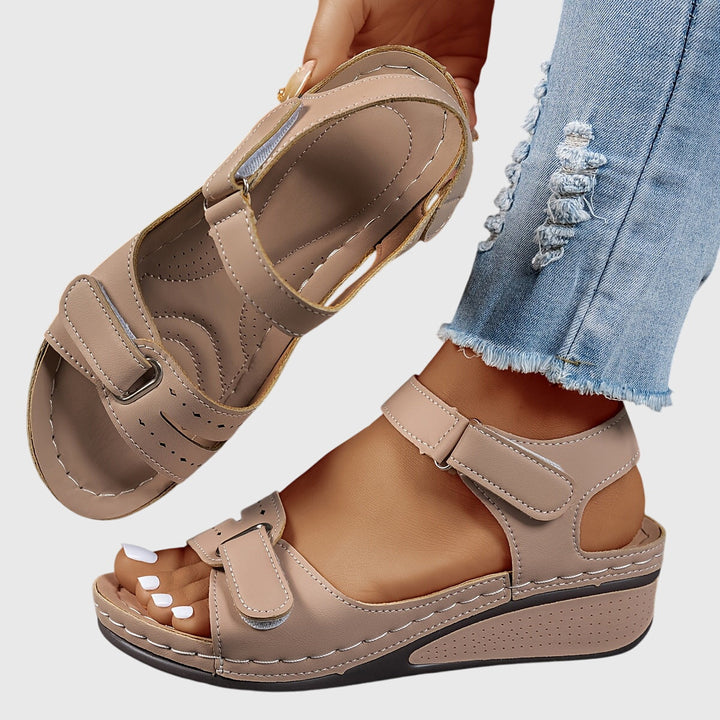 A woman wearing wide-fit supportive sandals with a relaxed summer outfit, walking with ease and confidence.