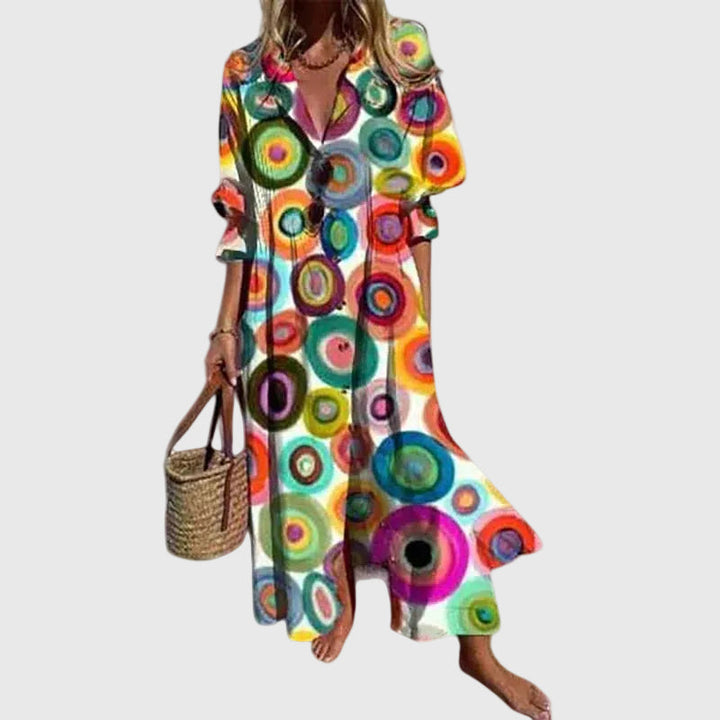 Woman in a long flowing boho-style maxi dress with delicate patterns, walking outdoors.