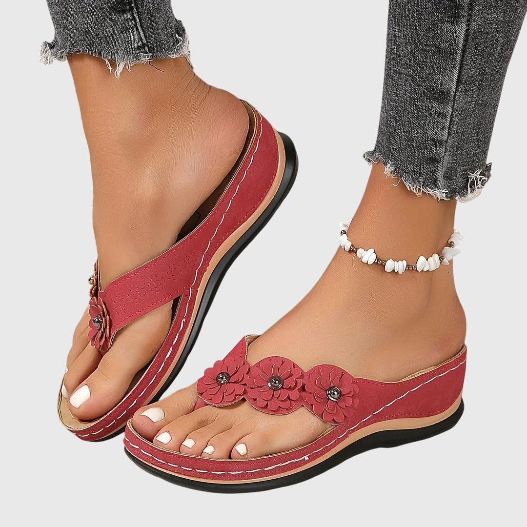 A woman wearing navy cushioned flip-flops with a supportive insole and open-front design.