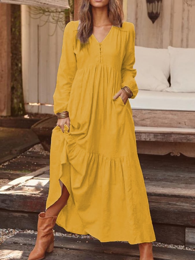 Woman walking through the countryside in the Georgia tiered maxi dress with long sleeves and a flowing flounced hem.