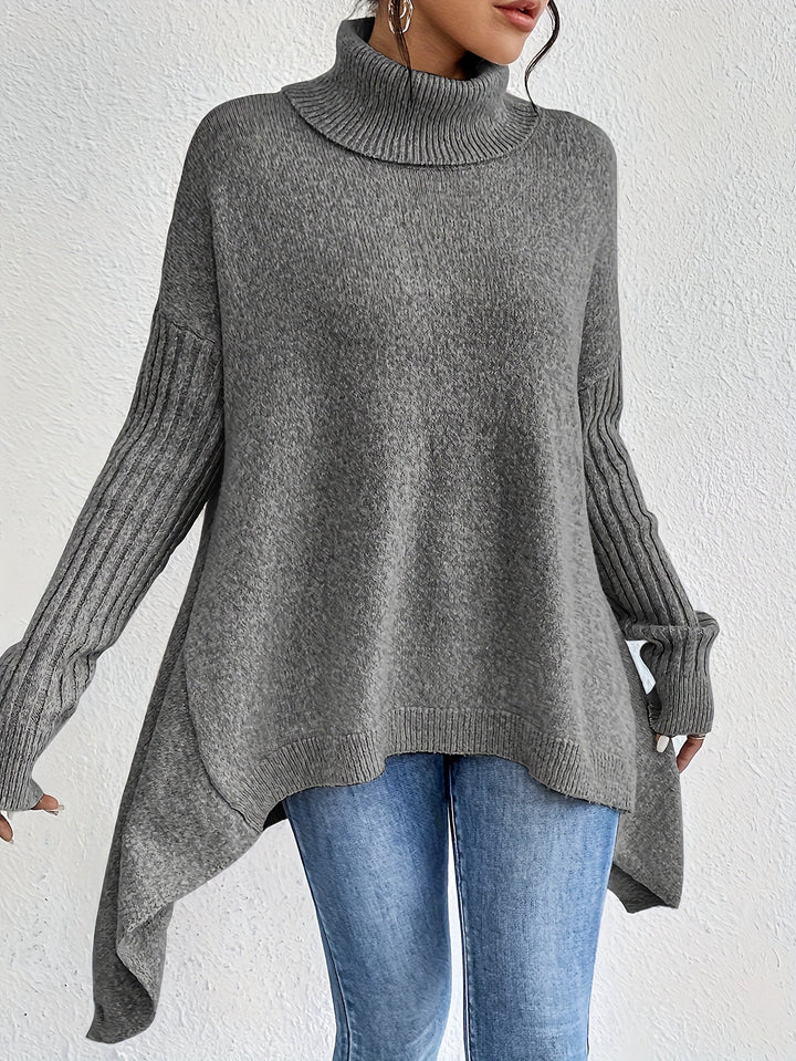 A woman wearing a stand-collar jumper with a chic asymmetric drape, warm and polished.