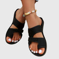 Lightweight flat sandal in black, also available in red and brown, with a simple clean design