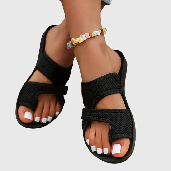 Lightweight flat sandal in black, also available in red and brown, with a simple clean design