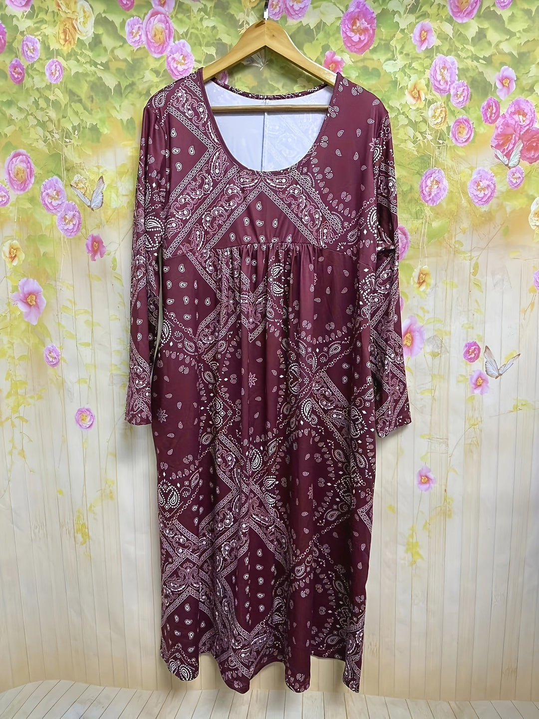A woman wearing the Maureen long sleeve grey paisley midi dress with a square neckline and flowing skirt, styled for a relaxed day out.
