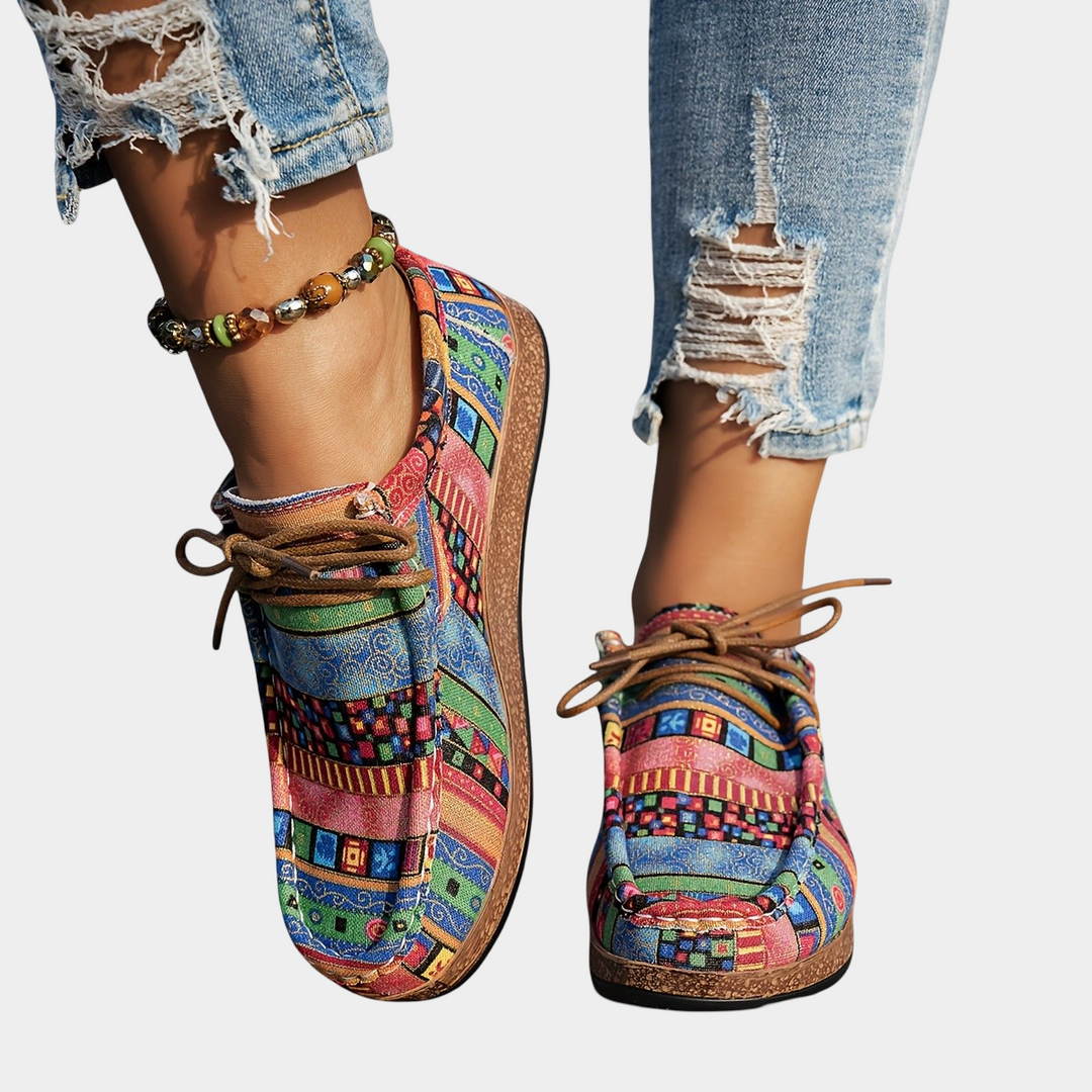 A woman wearing green boho-patterned lightweight trainers on a walk in town.