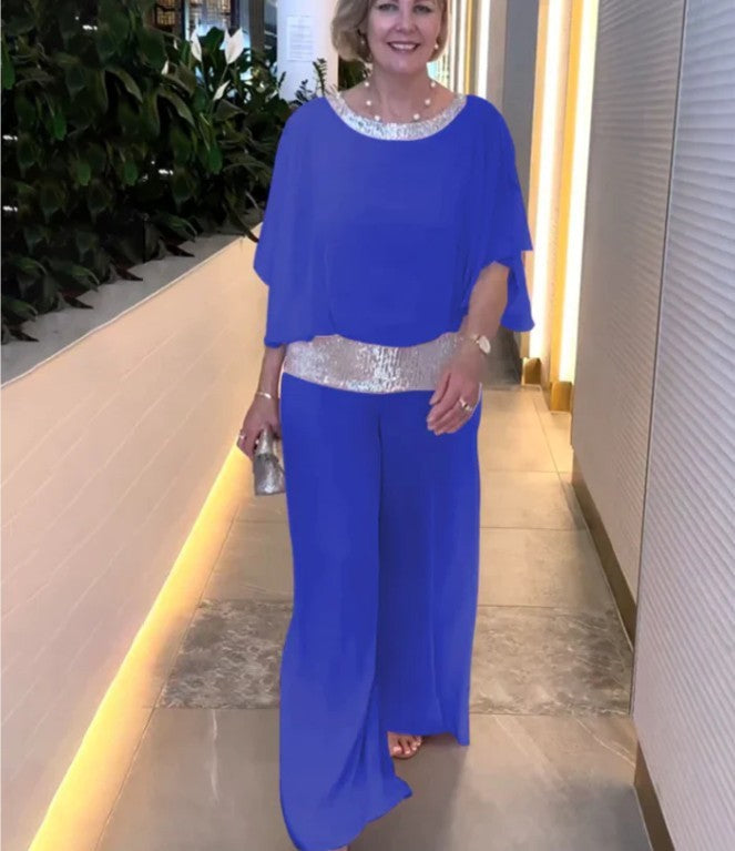 A woman wearing an embellished blouse-style top with softly flowing wide evening trousers.