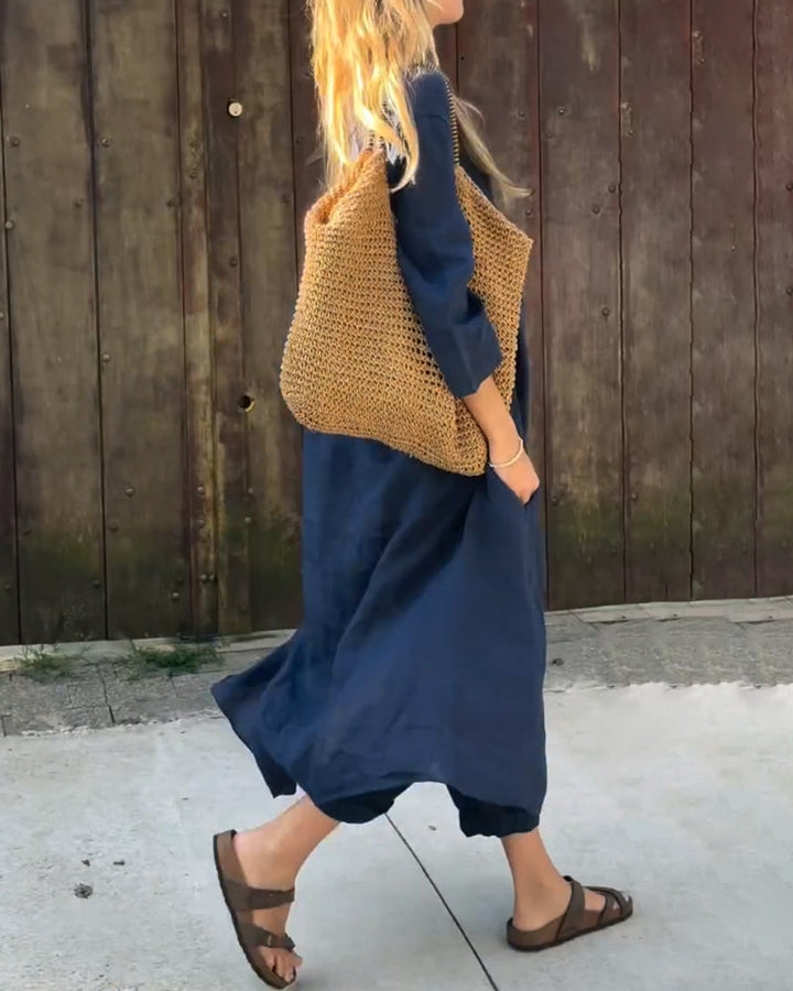 A woman wearing a blue asymmetric tunic with wide-leg trousers