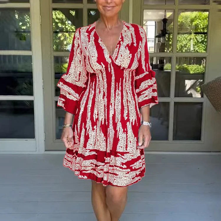 Woman wearing a boho print mini dress with ruffled sleeves and a soft V-neckline.