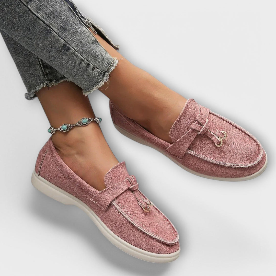 A woman wearing elegant loafers on a polished day out in the city.