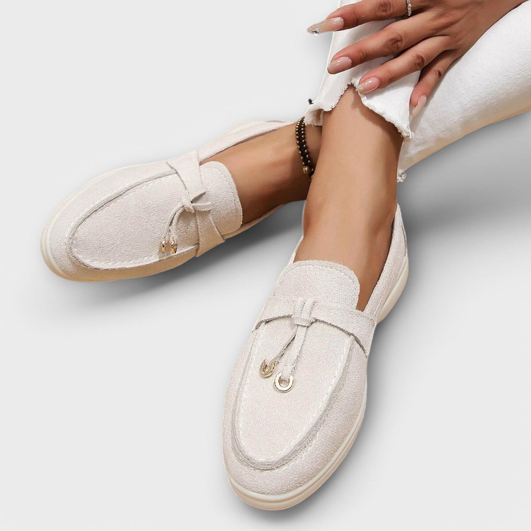 A woman wearing elegant loafers on a polished day out in the city.