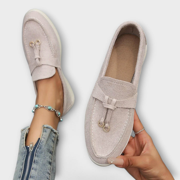 A woman wearing elegant loafers on a polished day out in the city.
