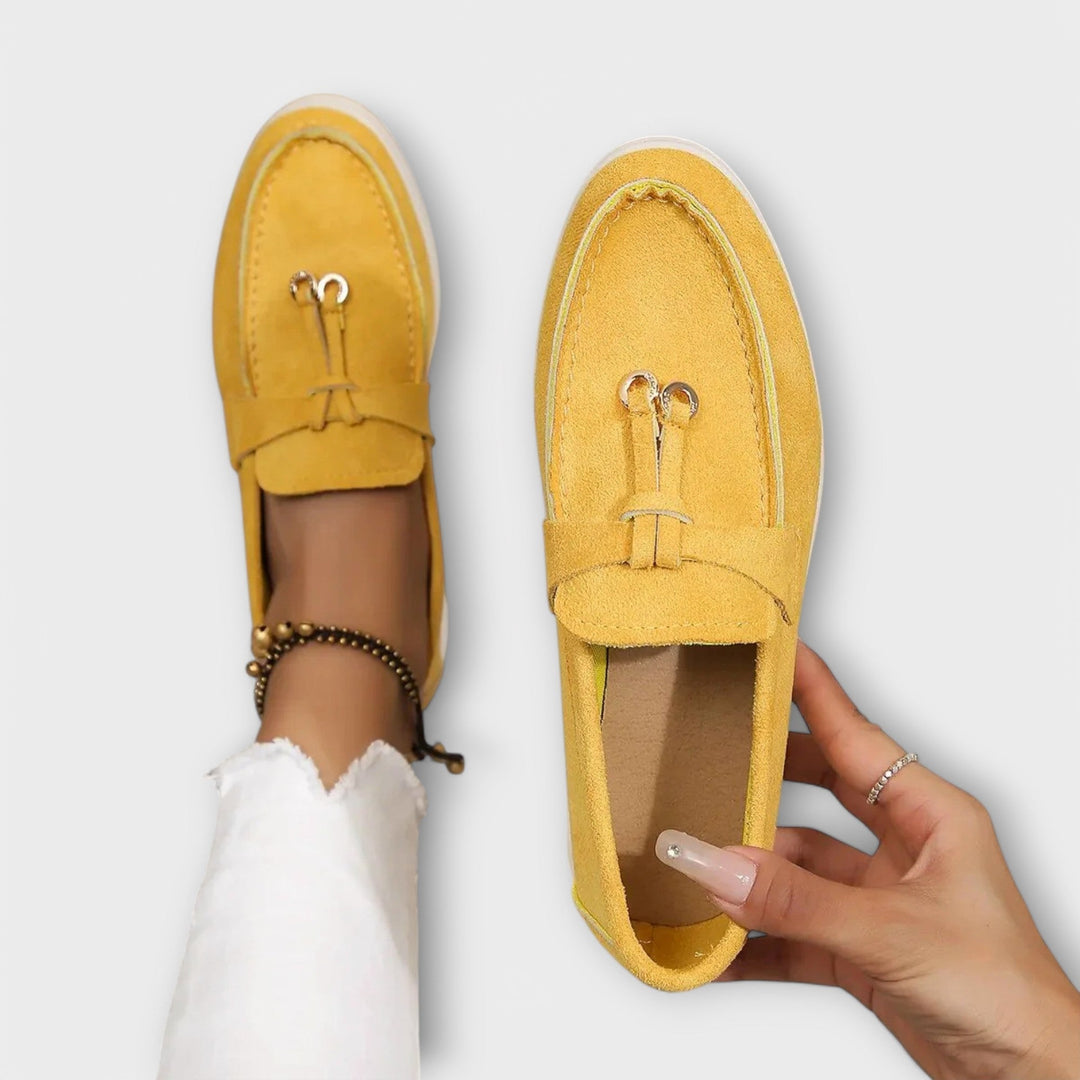 A woman wearing elegant loafers on a polished day out in the city.
