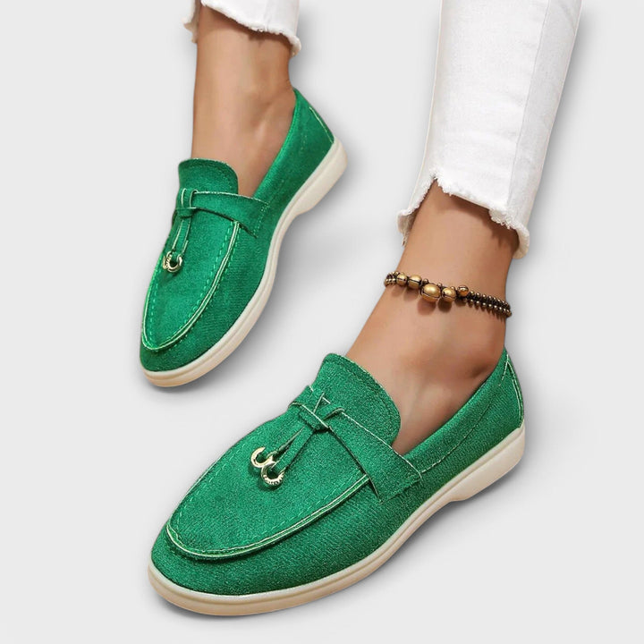 A woman wearing elegant loafers on a polished day out in the city.