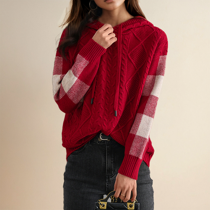 A woman wearing a soft cable-textured hooded jumper, cosy and warm with the hood down.