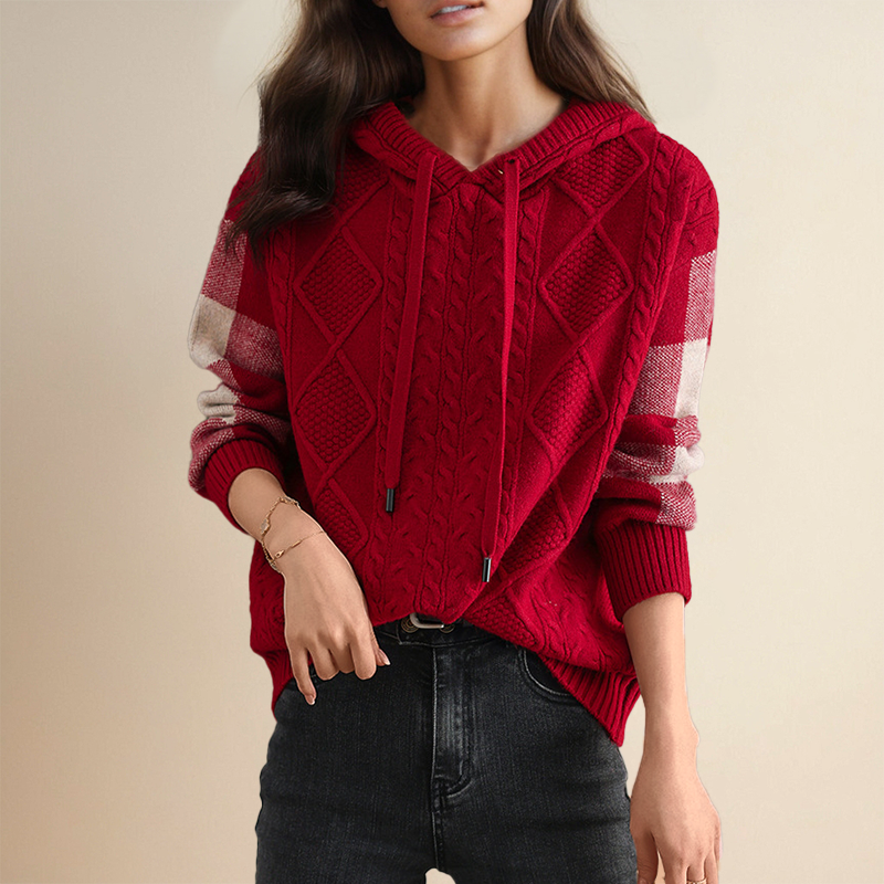 A woman wearing a soft cable-textured hooded jumper, cosy and warm with the hood down.