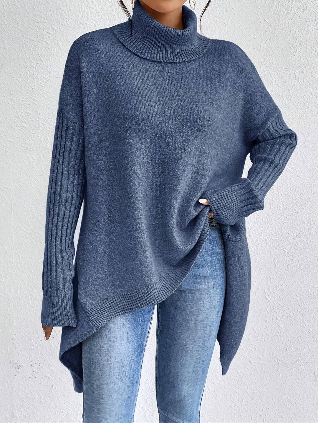 A woman wearing a stand-collar jumper with a chic asymmetric drape, warm and polished.