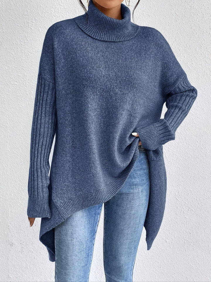 A woman wearing a stand-collar jumper with a chic asymmetric drape, warm and polished.