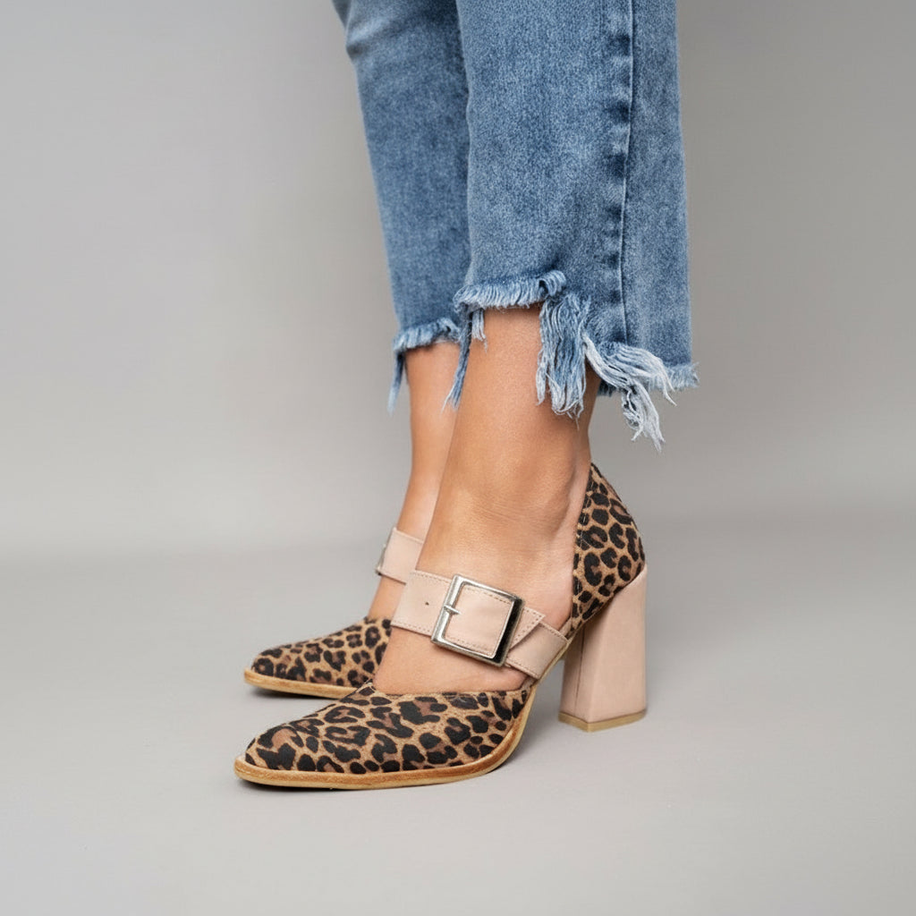 A woman wearing khaki pointed-toe high heels at a smart occasion.