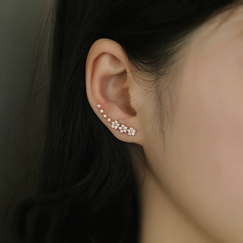 Rose gold floral crawler earrings with delicate sparkling floral motif following the curve of the ear