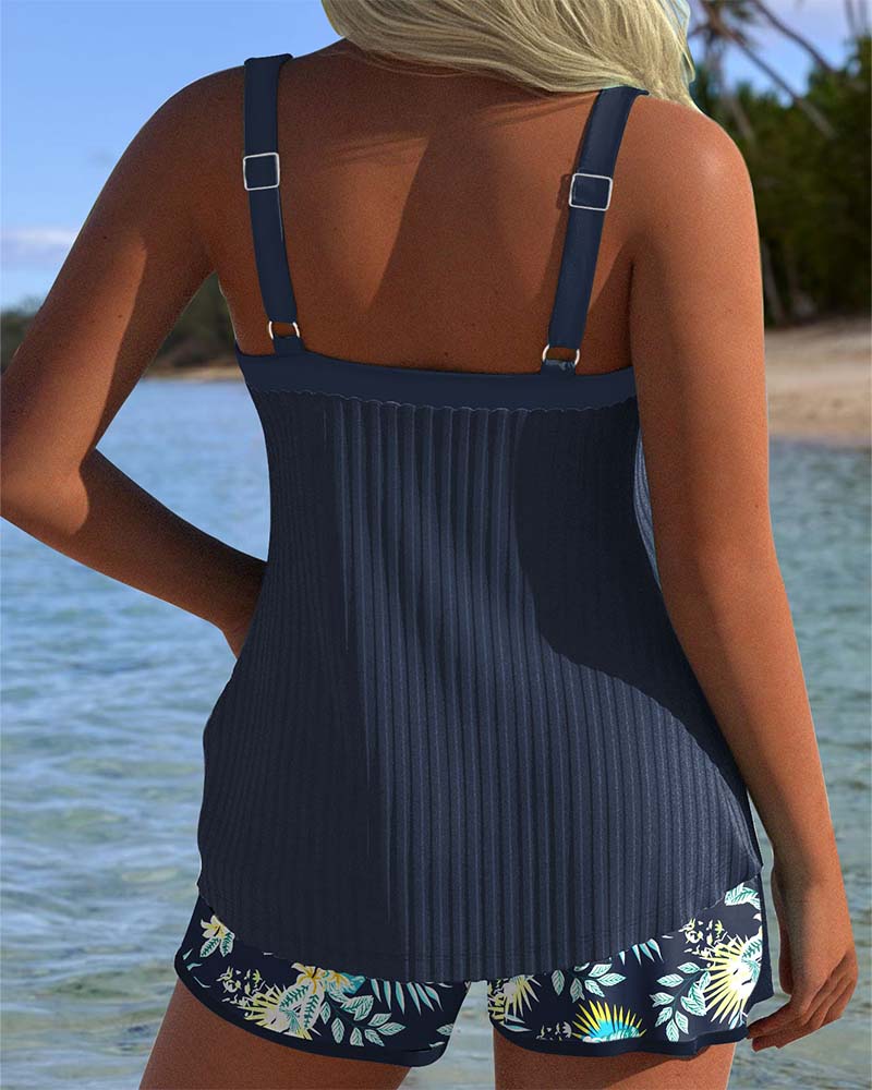 Navy and white striped tankini with matching shorts bottom, laid flat on a bright background
