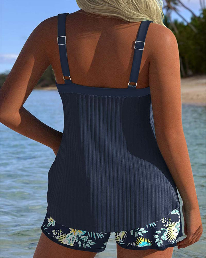 Navy and white striped tankini with matching shorts bottom, laid flat on a bright background