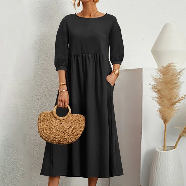 A woman wearing the Sheila fitted waist midi dress with three-quarter sleeves and a flowing skirt.