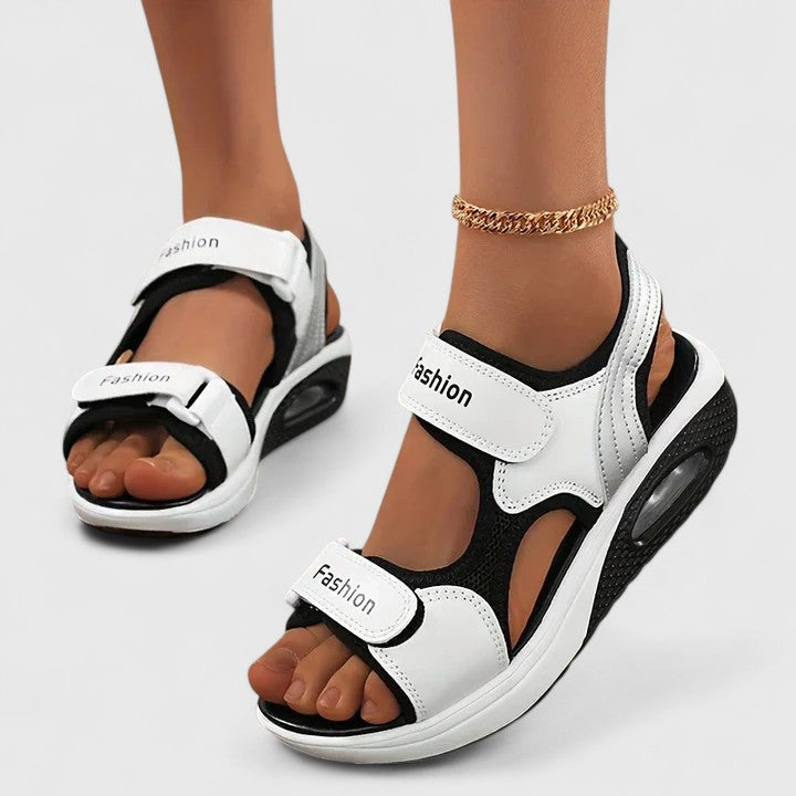 A woman in white sandals with a lilac trim walking comfortably, feet supported and light.
