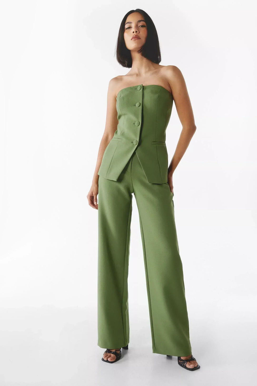 A woman wearing a tailored sleeveless button-detail top with matching wide-leg trousers.