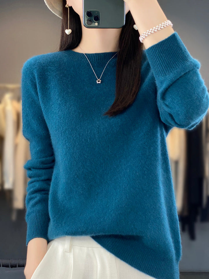 A woman wearing a super-soft warm jumper, relaxed and cosy on a chilly day.
