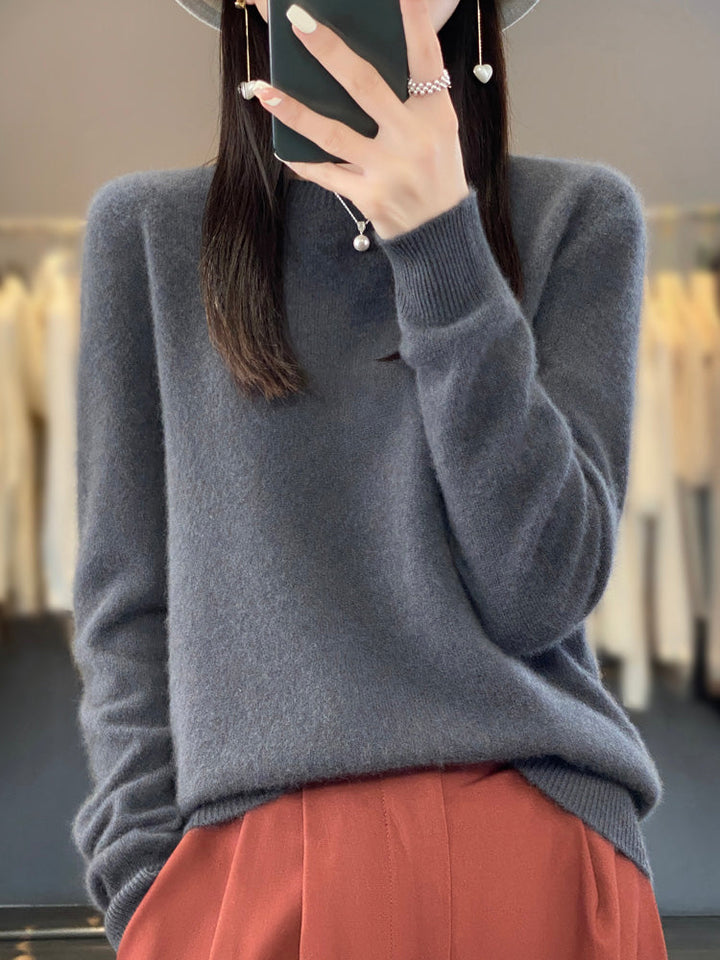 A woman wearing a super-soft warm jumper, relaxed and cosy on a chilly day.