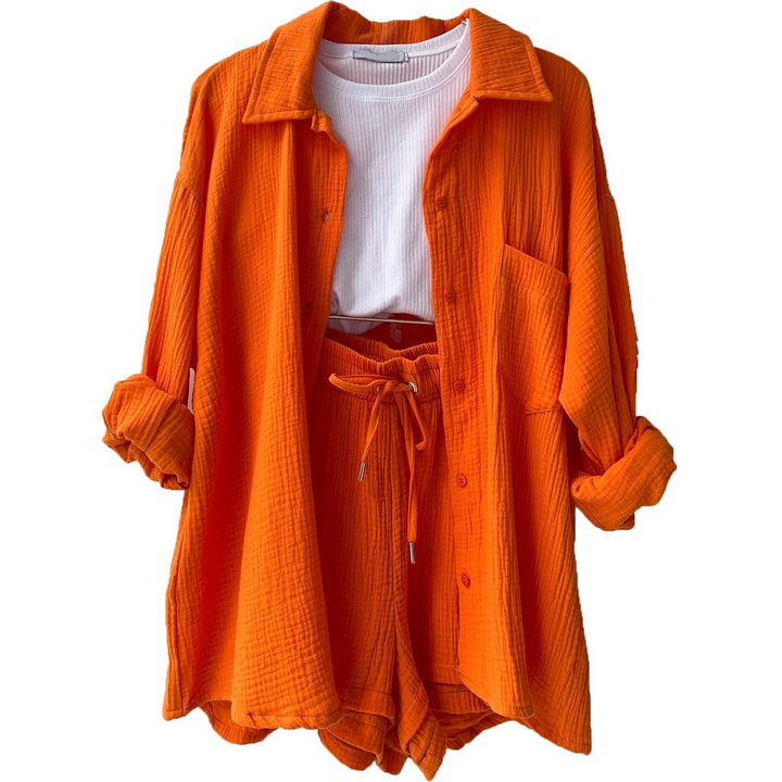 A woman wearing a relaxed button shirt with matching drawstring shorts, fresh and easy.