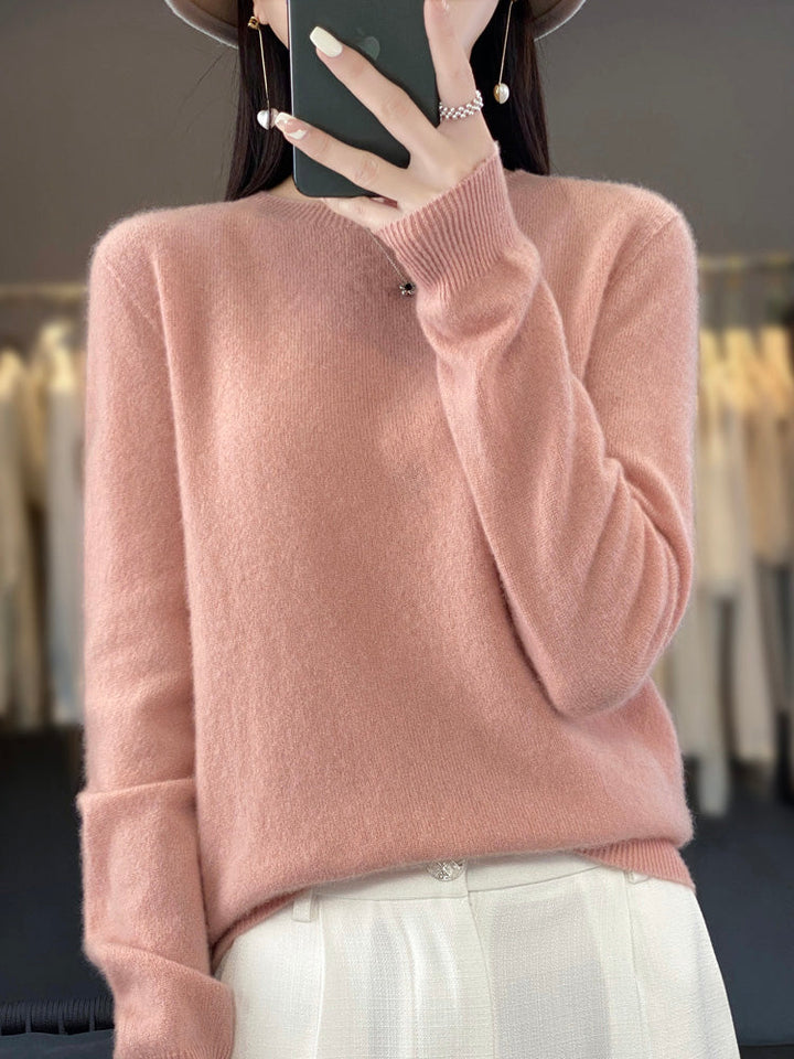 A woman wearing a super-soft warm jumper, relaxed and cosy on a chilly day.