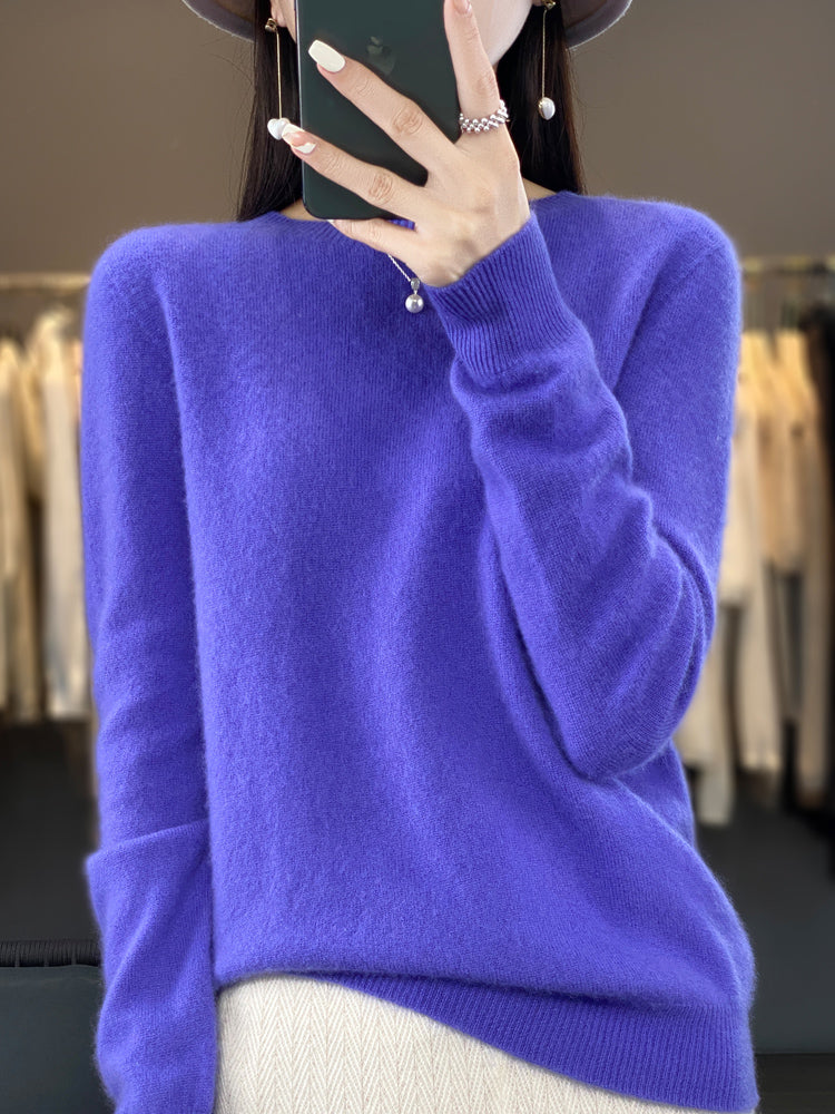 A woman wearing a super-soft warm jumper, relaxed and cosy on a chilly day.