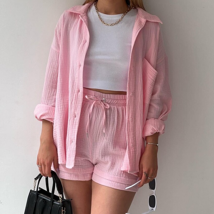 A woman wearing a soft V-neck blouse with matching playful shorts, fresh and relaxed.
