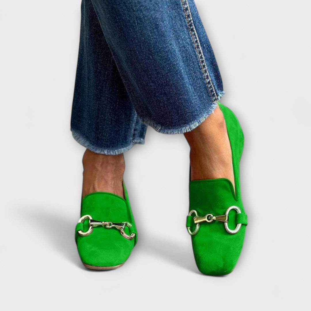 A woman wearing slip-on loafers with an elegant buckle detail, dressed for a special afternoon.