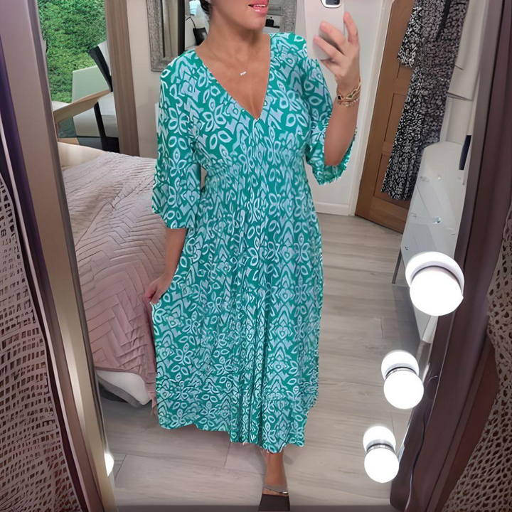 Woman wearing the Nuala™ bold printed boho maxi dress with a V-neckline, smiling outdoors in the sunshine.