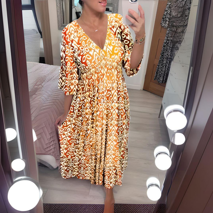 Woman wearing the Nuala™ bold printed boho maxi dress with a V-neckline, smiling outdoors in the sunshine.