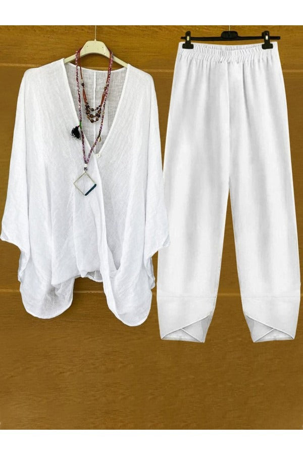 A woman wearing a flowing V-neck knot-detail top with matching flared trousers.