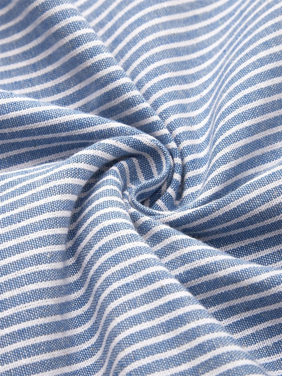 A woman wearing the Margaret striped midi dress with button details, standing outdoors on a bright day.