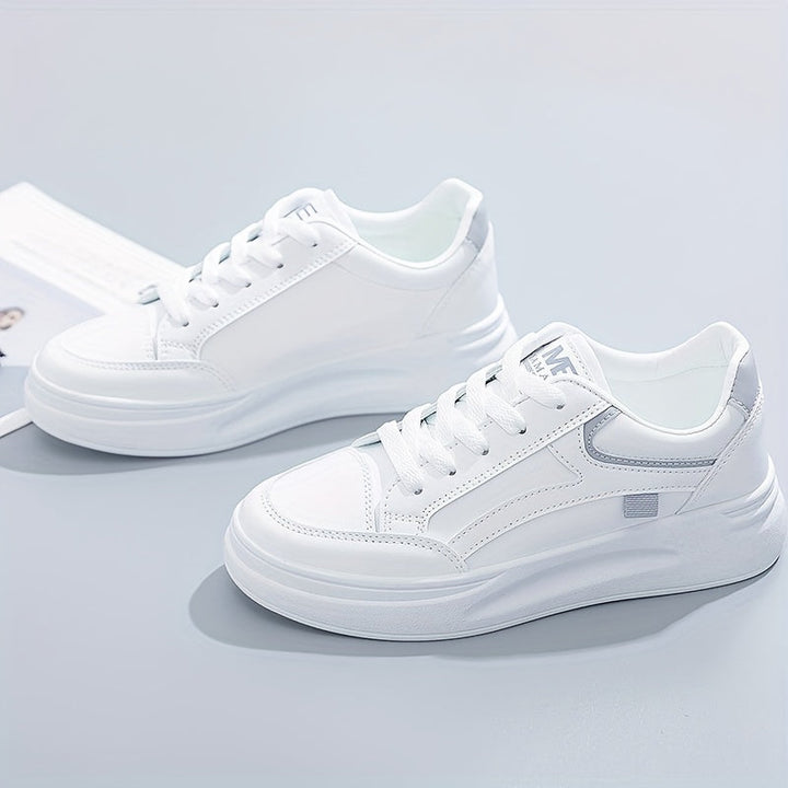 A woman in crisp white light comfort trainers paired with jeans.