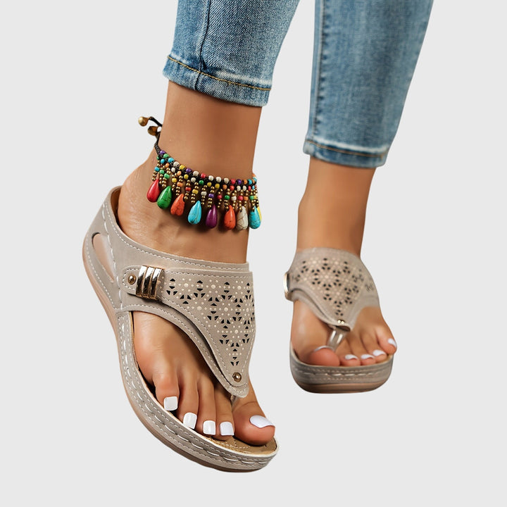A woman in grey comfort flip-flops relaxing outdoors, feet cushioned and supported.