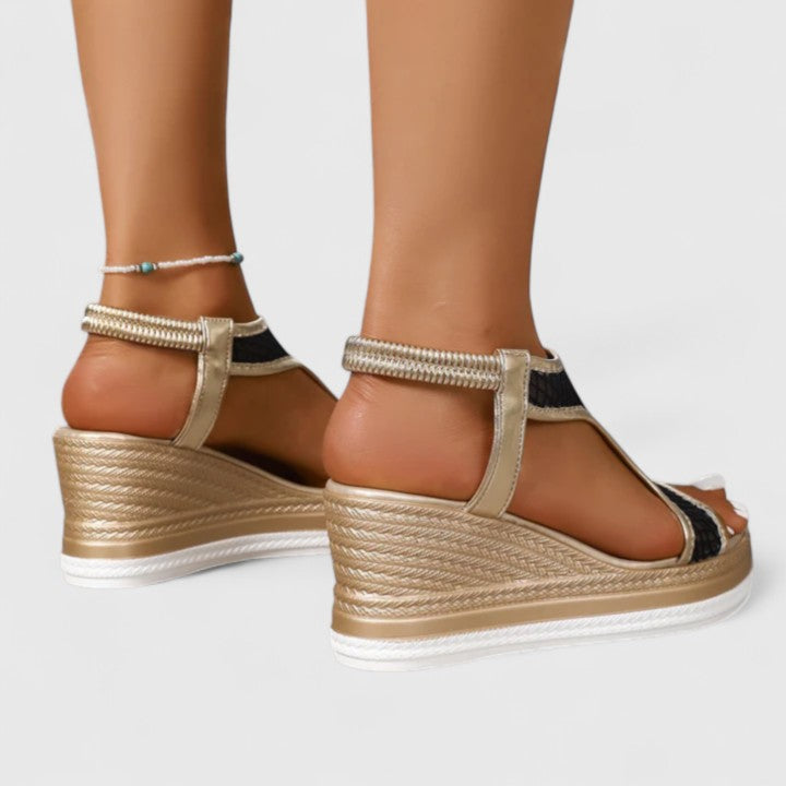 A woman wearing beige chic sandals with a cushioned sole and adjustable strap.